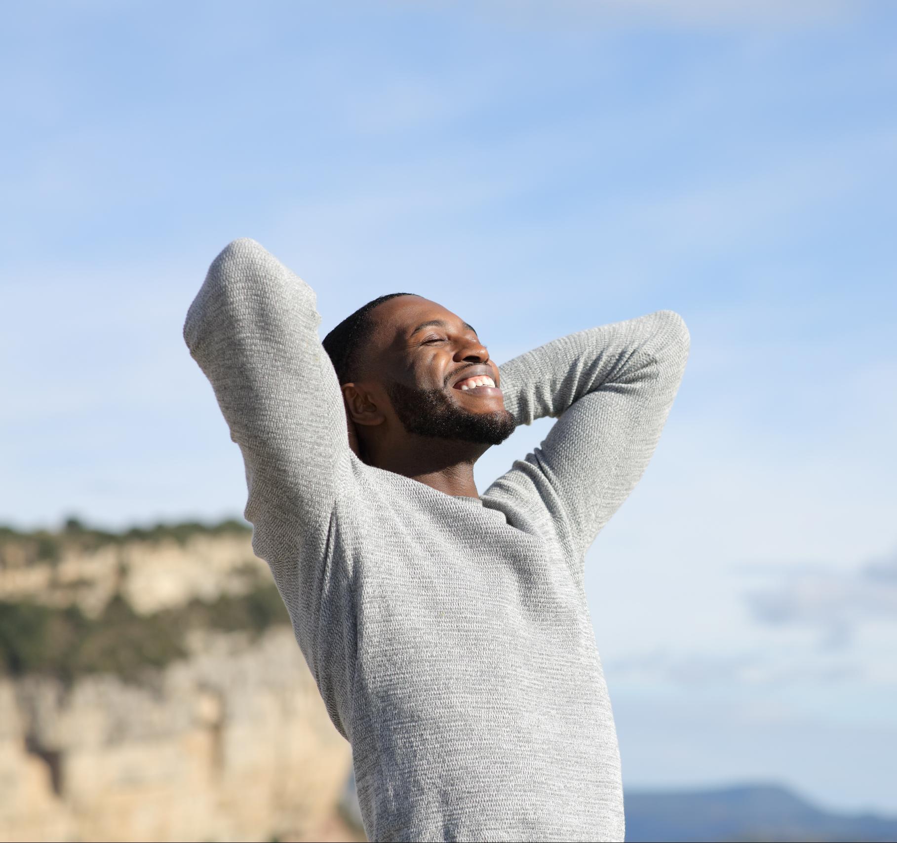 Relaxed man with black skin breathing in the mountain